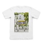 White t-shirt with a printed design of a coffee shop exterior on a white background